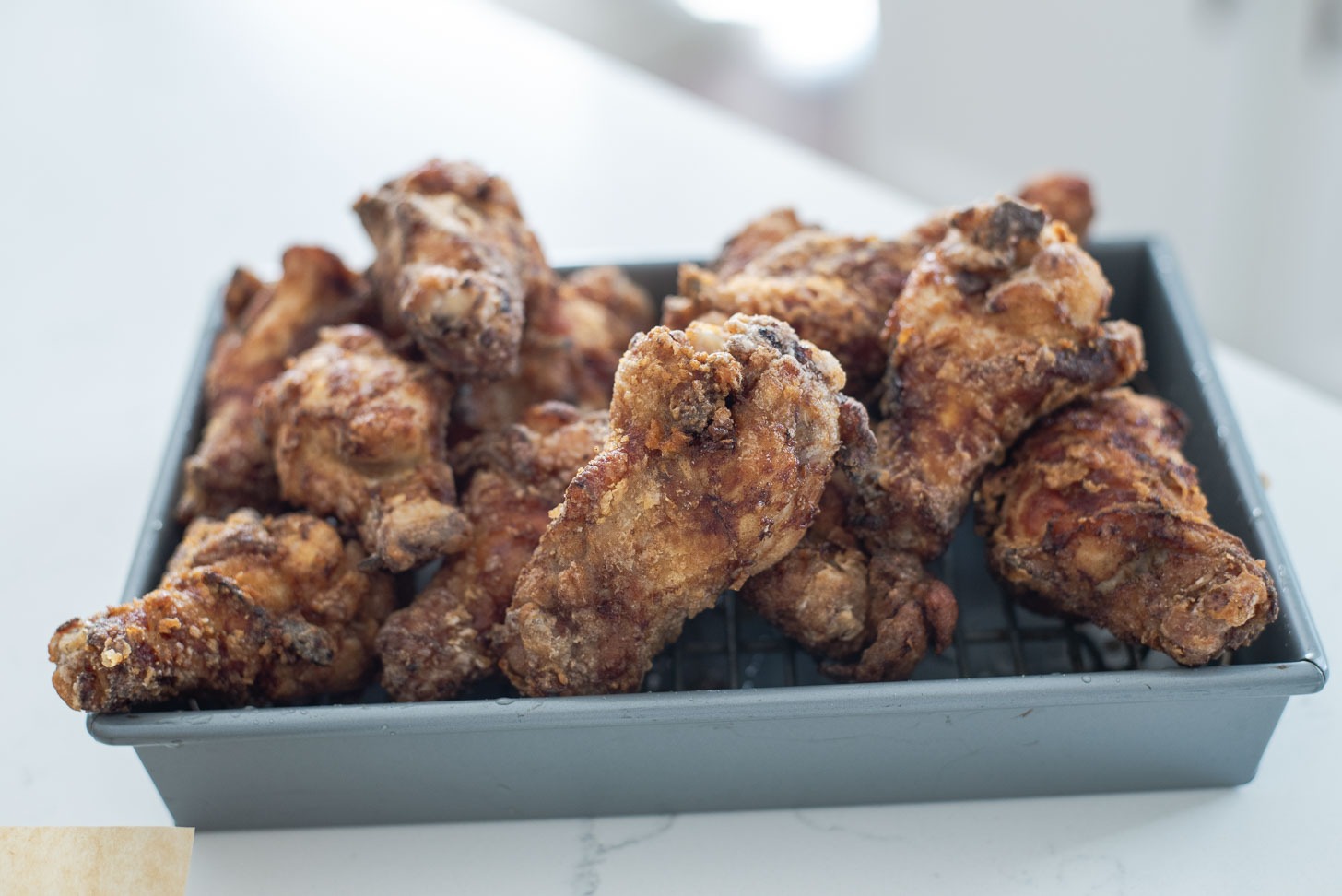 Double deep-fried chicken wings are golden brown and crisp.