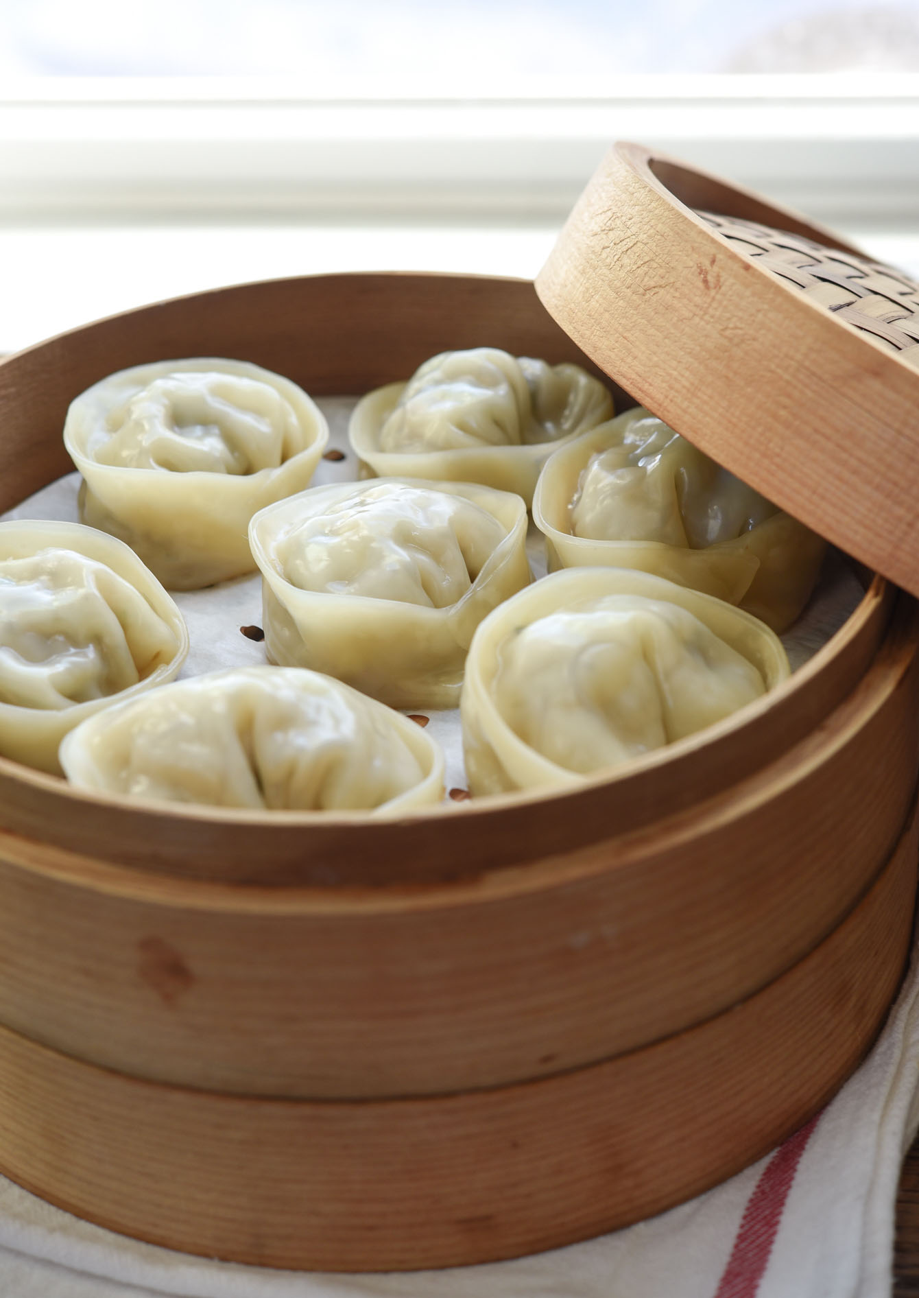 Steamed mandu in a bamboo steamer.