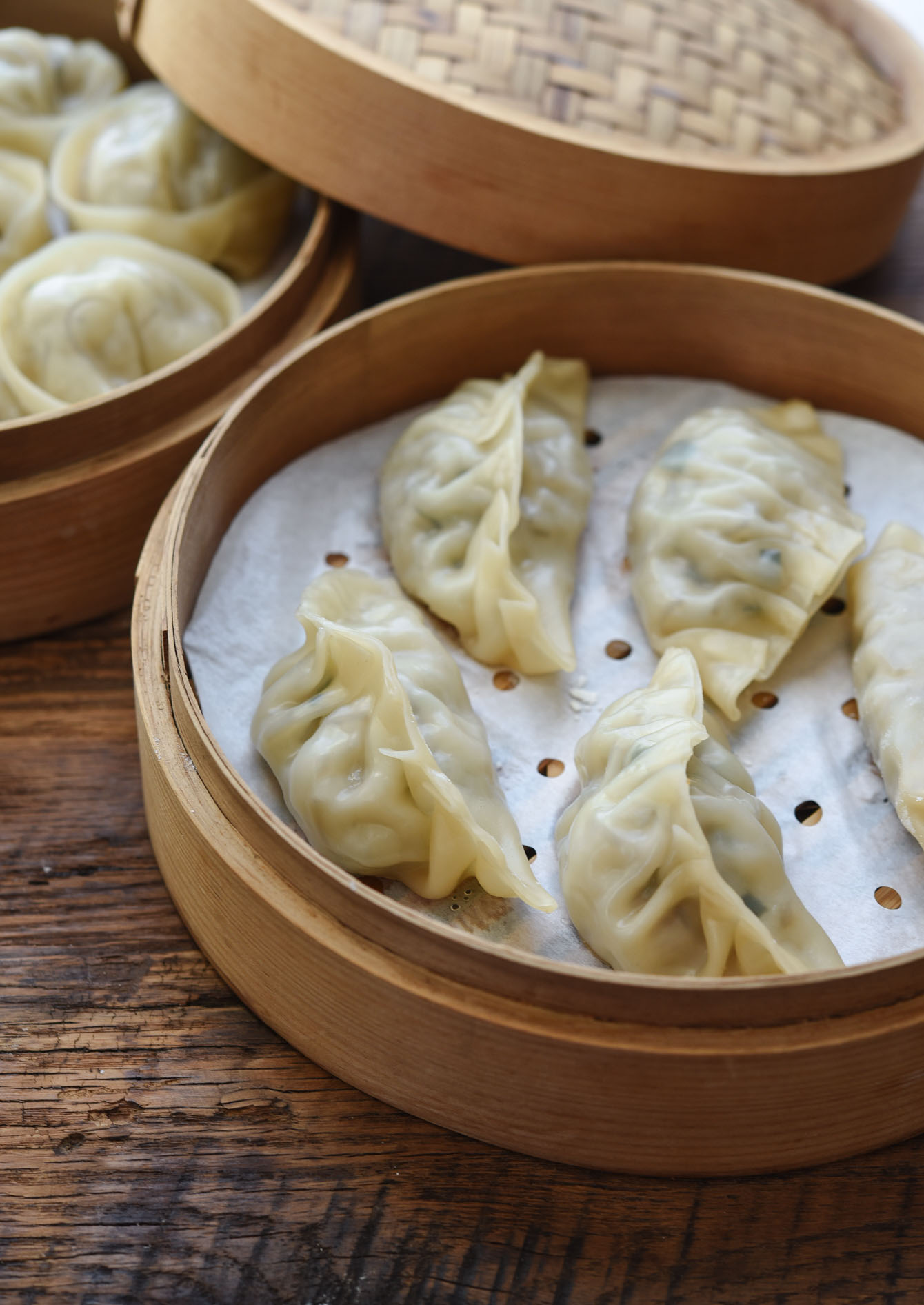 Mandu folded with leaf pattern steamed in a bamboo basket.