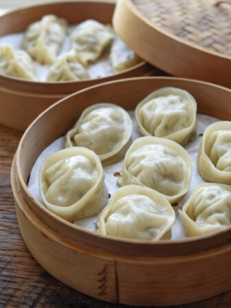 Mandu (Korean dumplings) steamed in bamboo baskets.