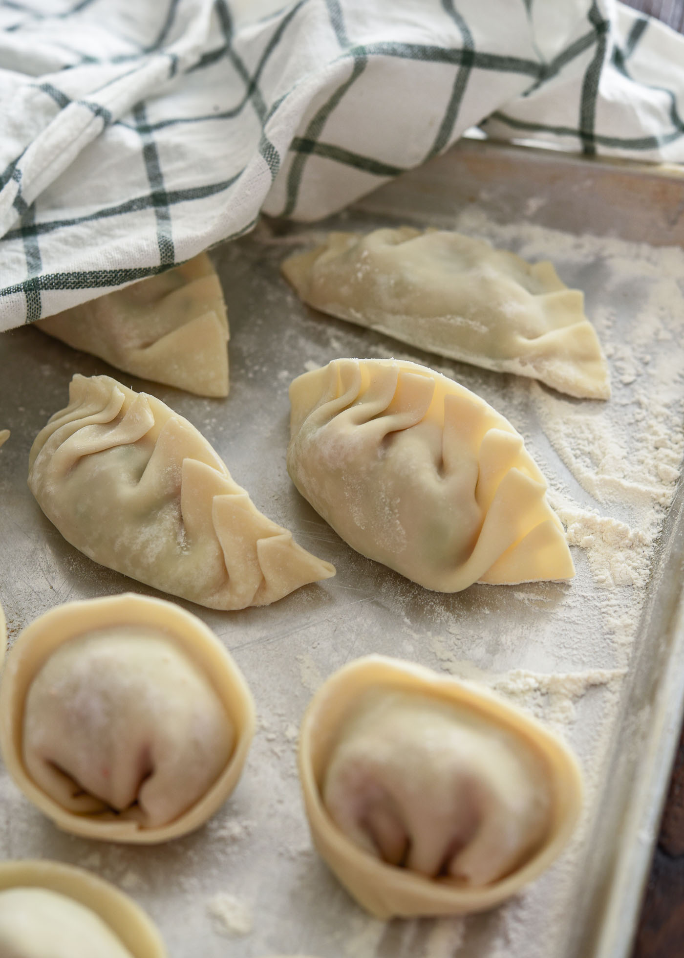 Pleated shape mandu (Korean dumplings) placed on a floured surface.