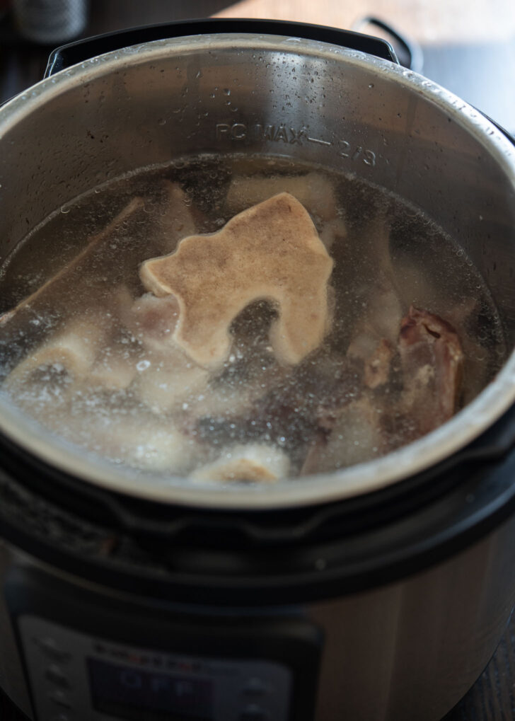 Adding more water to the beef bones to make second batch of bone broth.