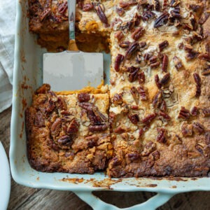 Pumpkin pie crunch with a serving spatula in a pan.