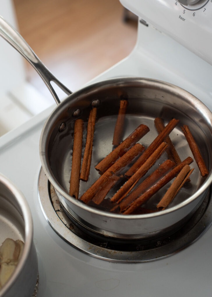 Cinnamon sticks simmering in a pot of water.