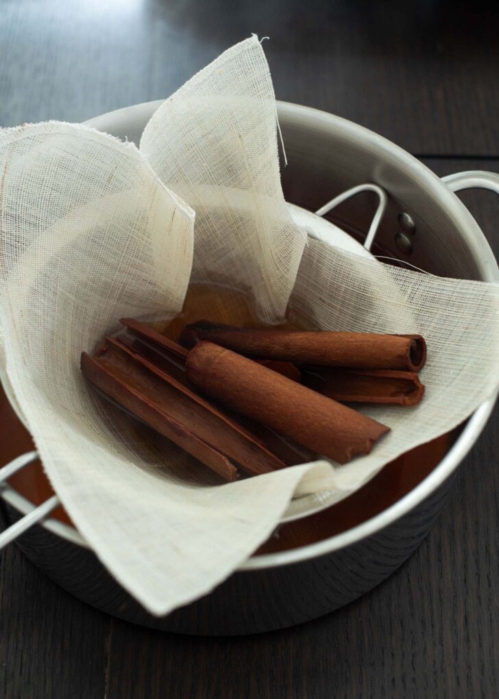 Cinnamon drink straining through kitchen cloth.