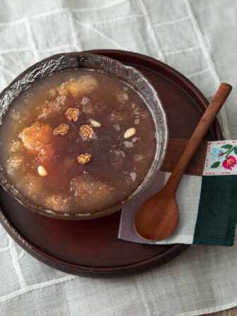 Cold Korean cinnamon punch (sujeonggwa) with ice and persimmon.