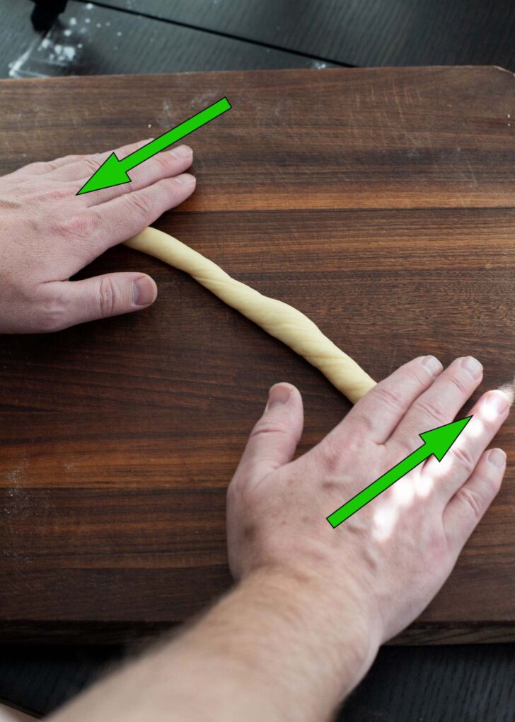 Both hands rolling each end of dough rope in opposite direction.