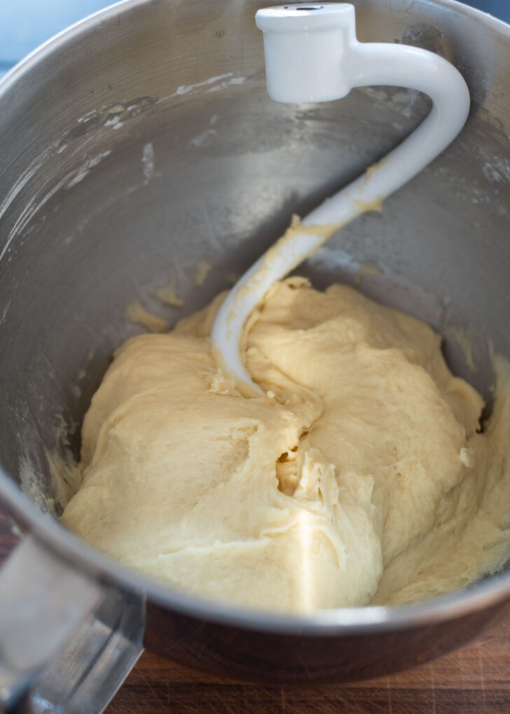 Twisted donut dough is kneaded in a standing mixer.