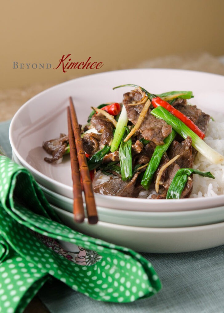 Beef with ginger and green onion stir fry served in a dish.
