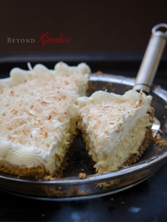 Coconut cream pie sliced in a pie dish.