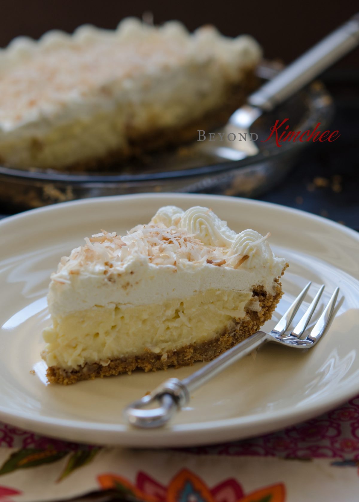 A slice of coconut cream pie on a serving dish.