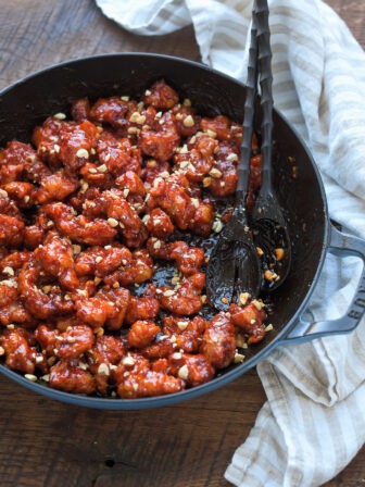 Crispy Korean chicken nuggets coated coated with sauce in a pan.