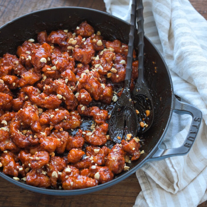 Crispy Korean chicken nuggets coated coated with sauce in a pan.