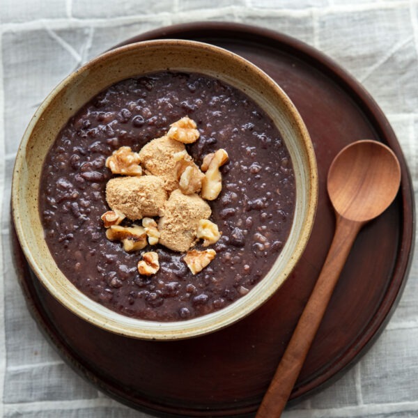 Danpatjuk garnished with injeolmi and nuts in a serving bowl.