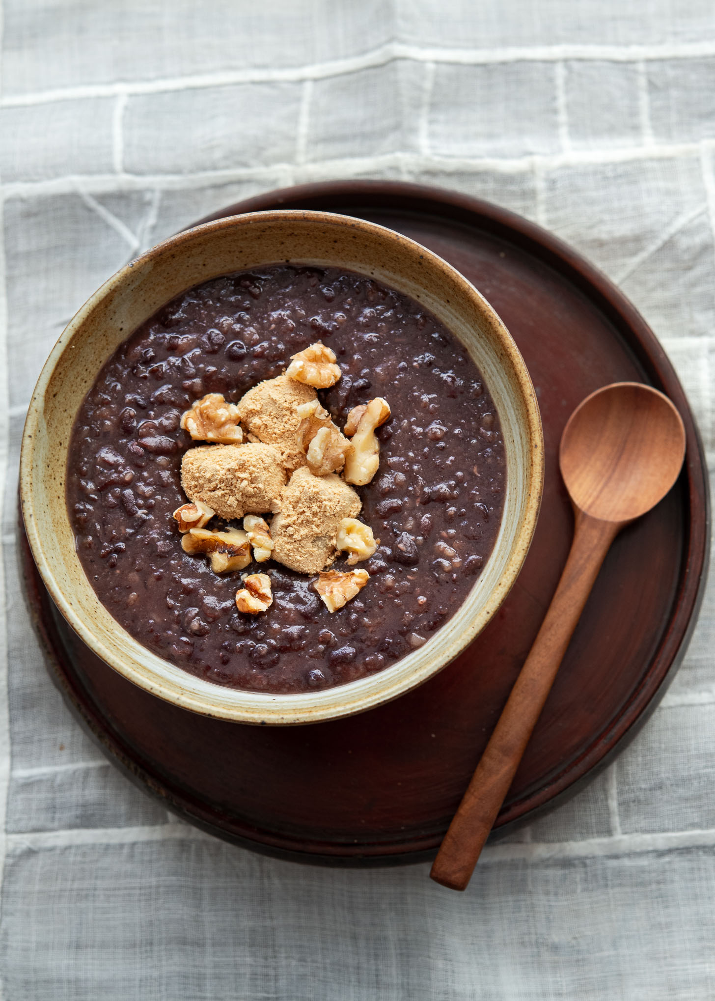 Danpatjuk garnished with injeolmi and nuts in a serving bowl.