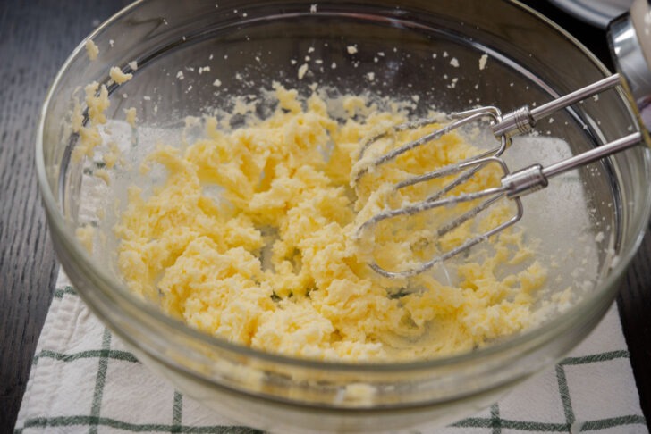 Wet ingredients mixed by hand mixer in a bowl.