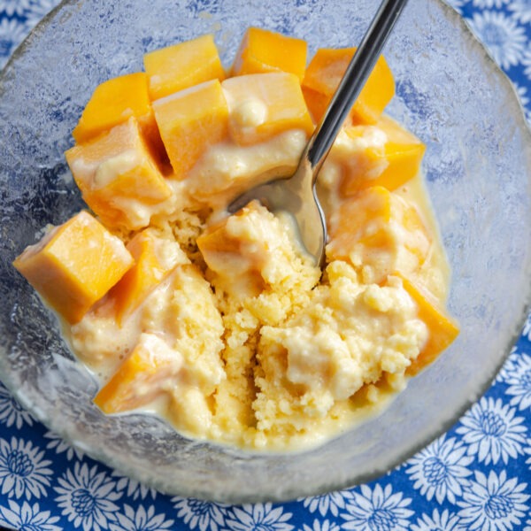 Shaved ice with fresh mango pieces in a bowl.