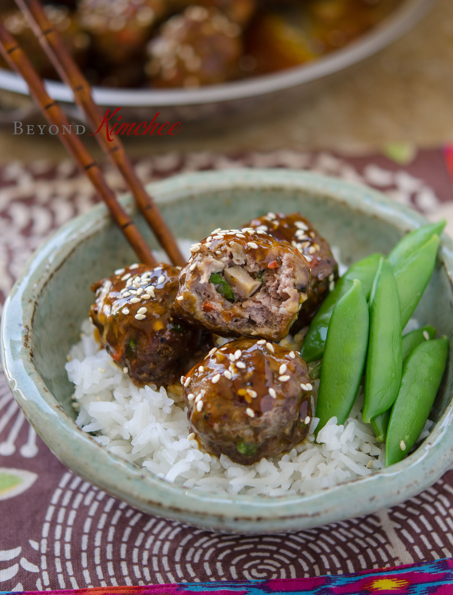 Beef meatballs with rice and snow peas.