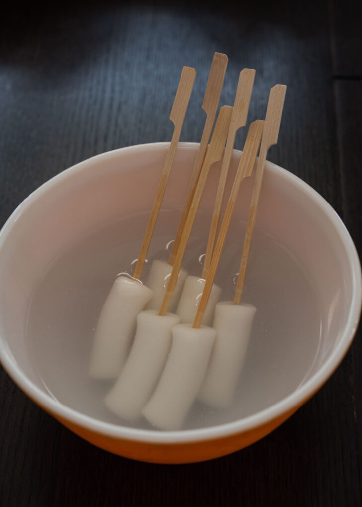 Wooden skewers inserted in rice cakes.