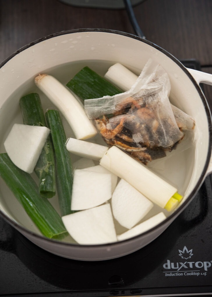 Korean fish can soup broth ingredients in a pot.