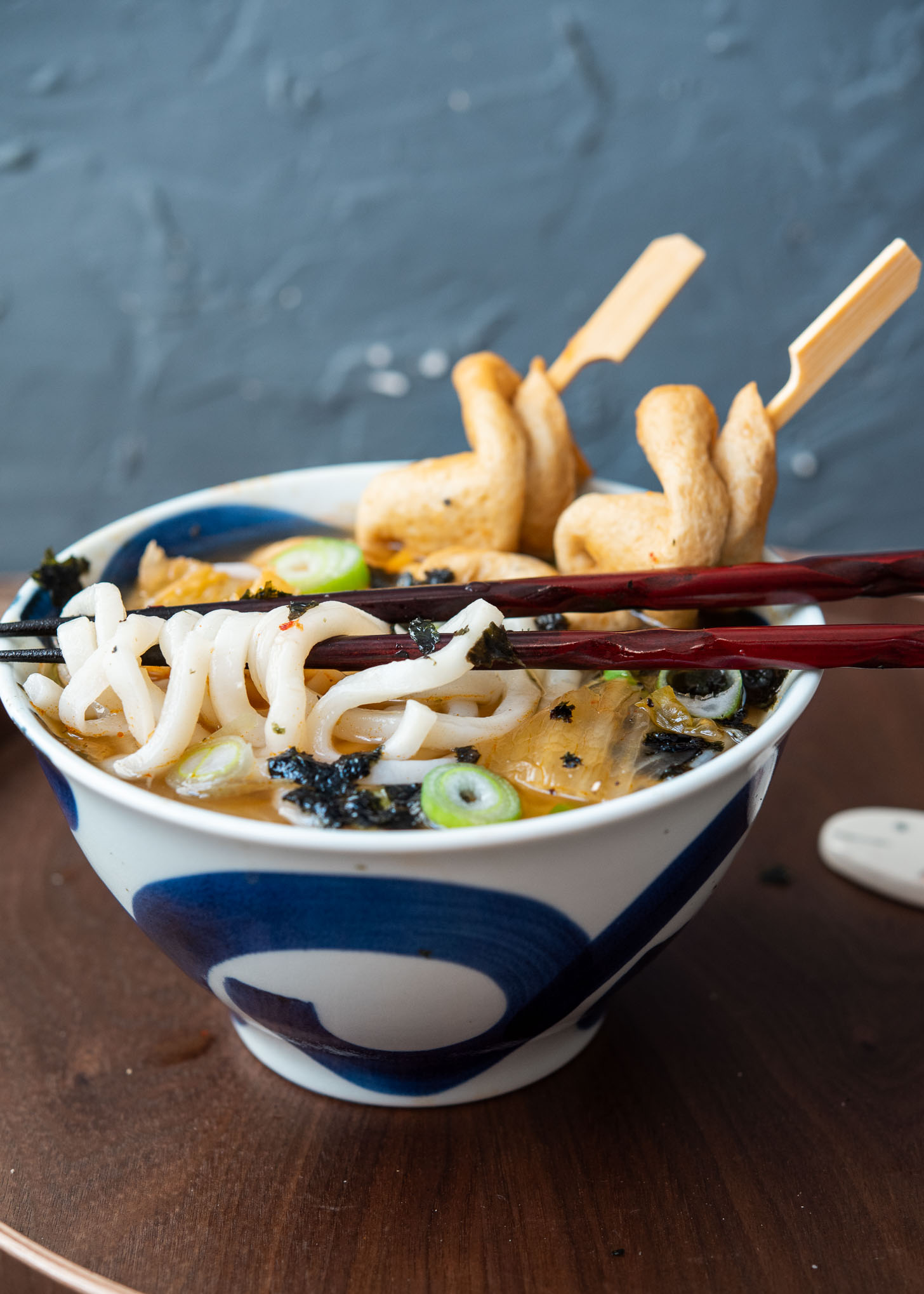 Chewy udon noodles with kimchi flavored dashi soup in a bowl.