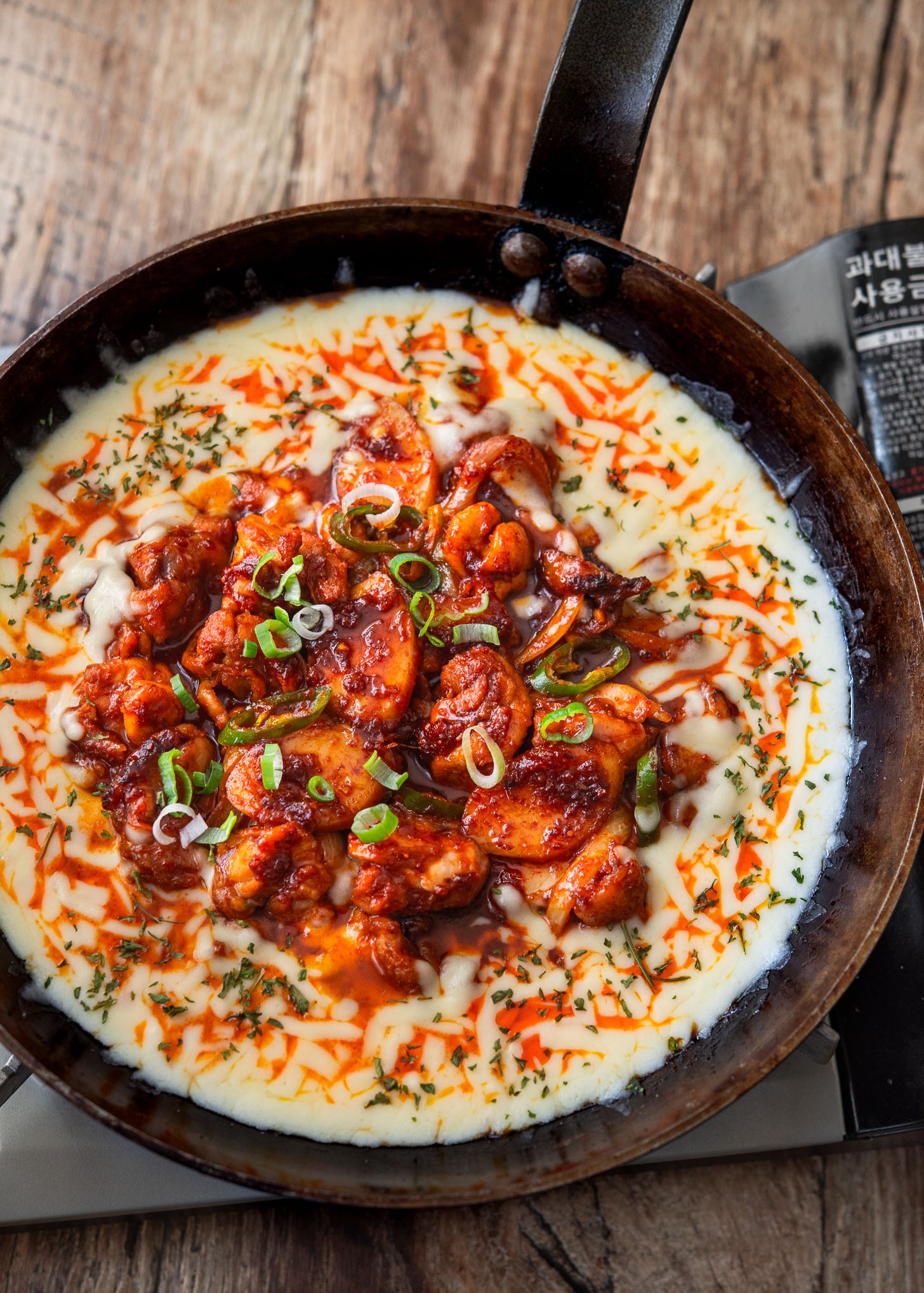 Buldak, Korean fire chicken, with melted cheese in a skillet.