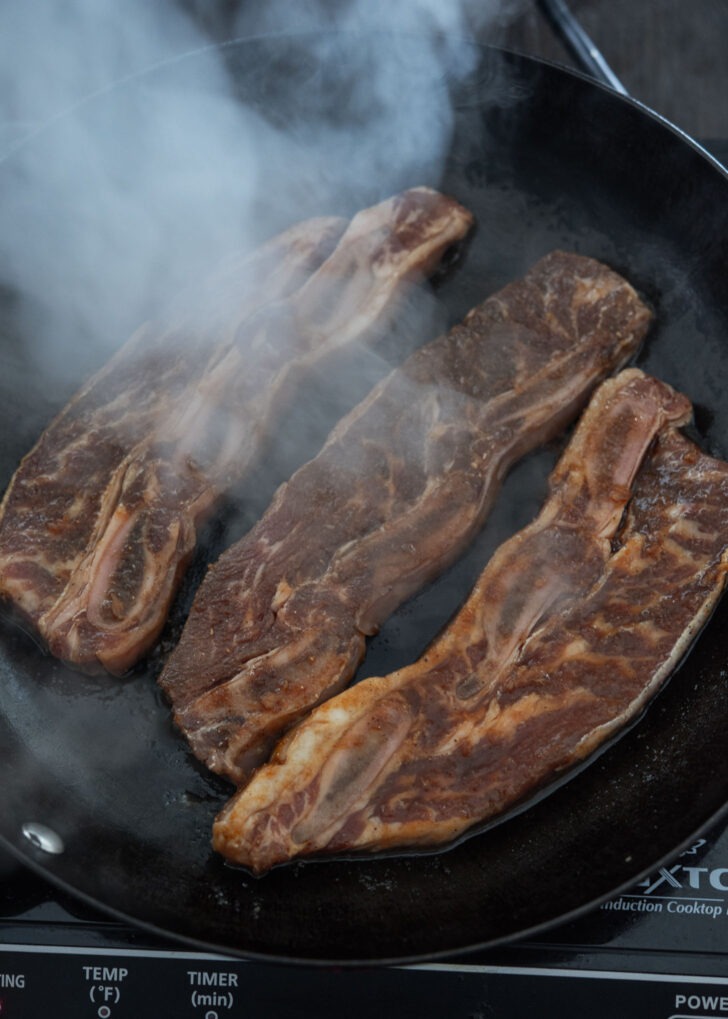 Pan searing LA galbi on a skillet.