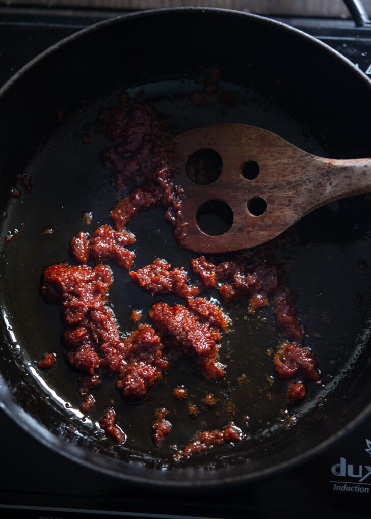 Canned massaman curry paste frying in oil.