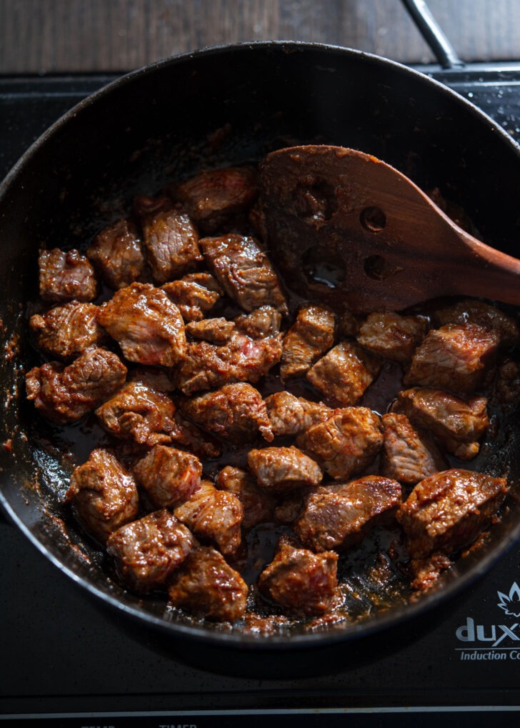 Adding beef chunk to curry paste to brown.