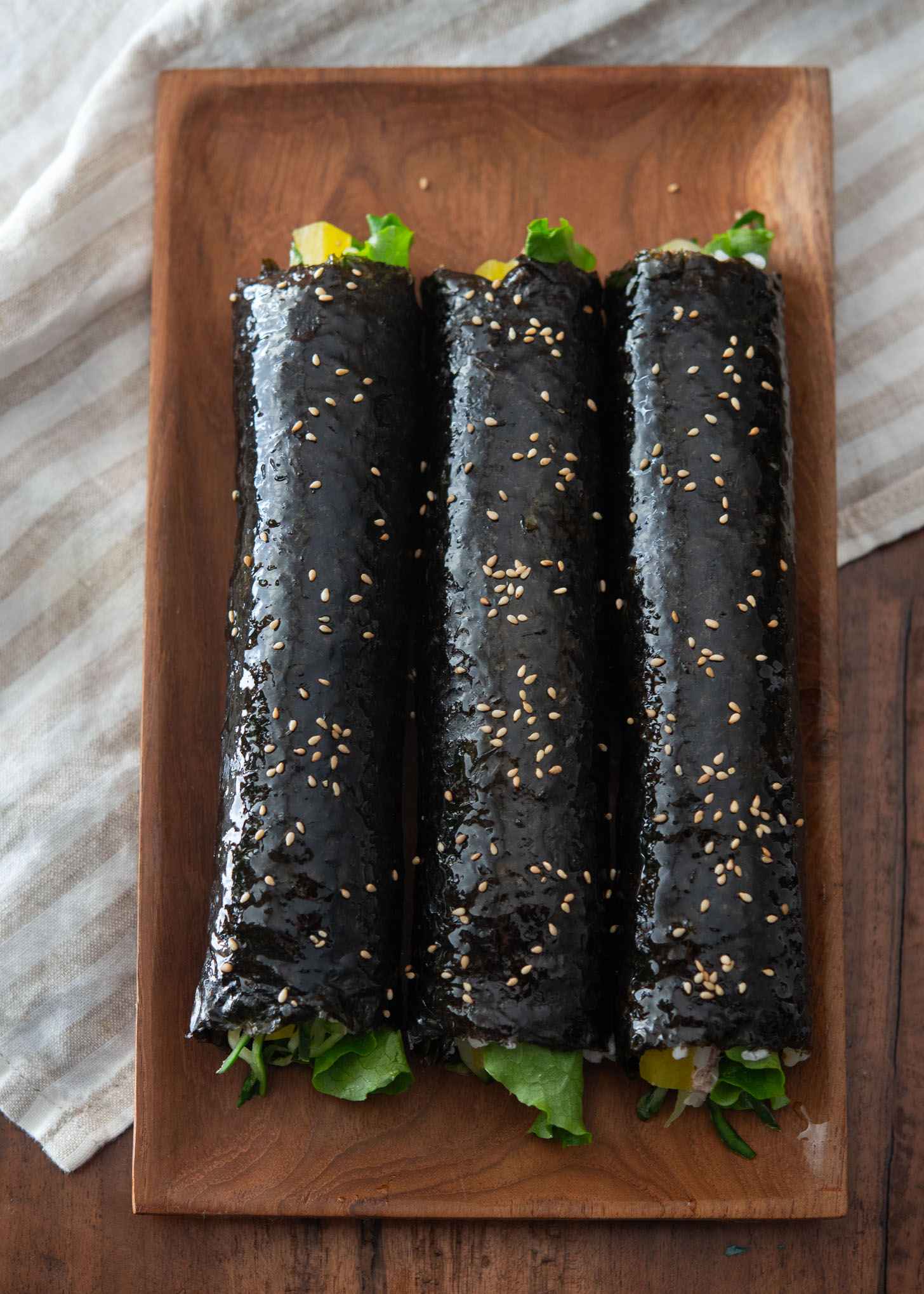 Sesame oil and sesame seeds applied to Korean tuna rice rolls.