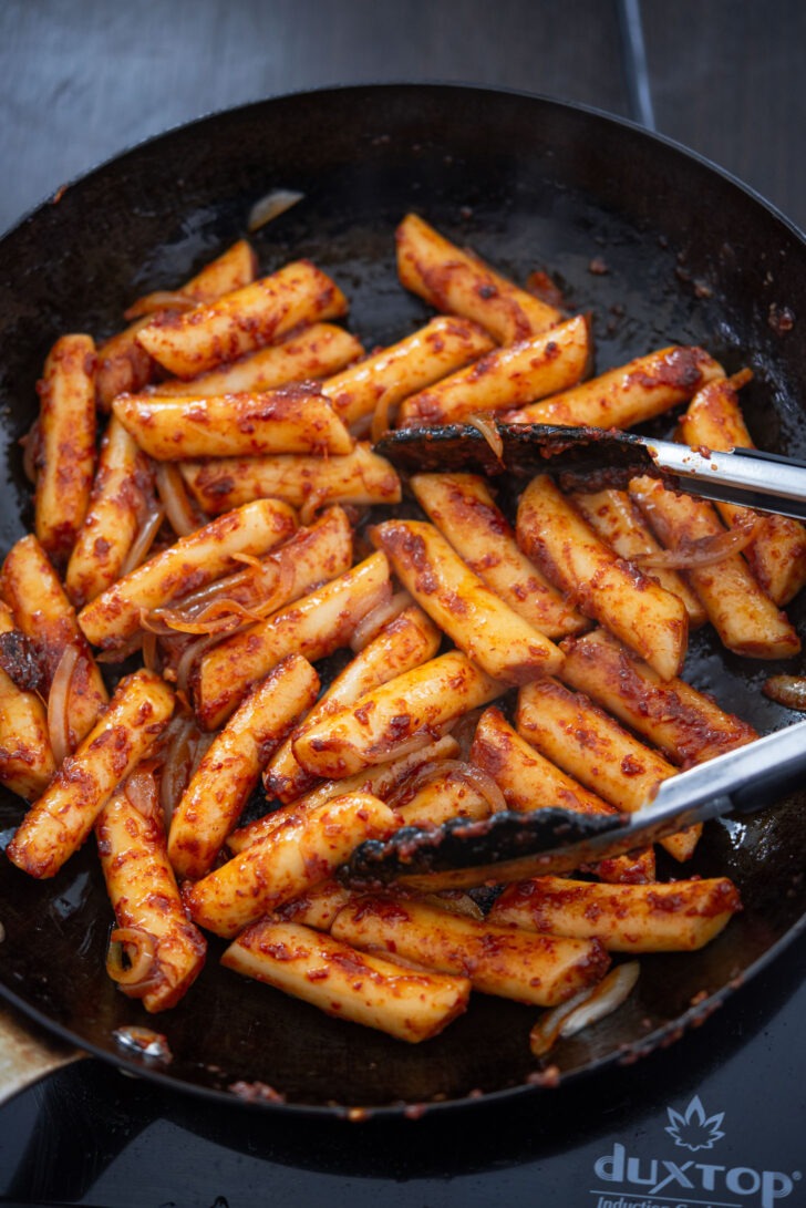 Gireum tteokbokki pan frying in oil in a skillet.