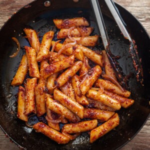 Pan fried rice cake in a skillet.