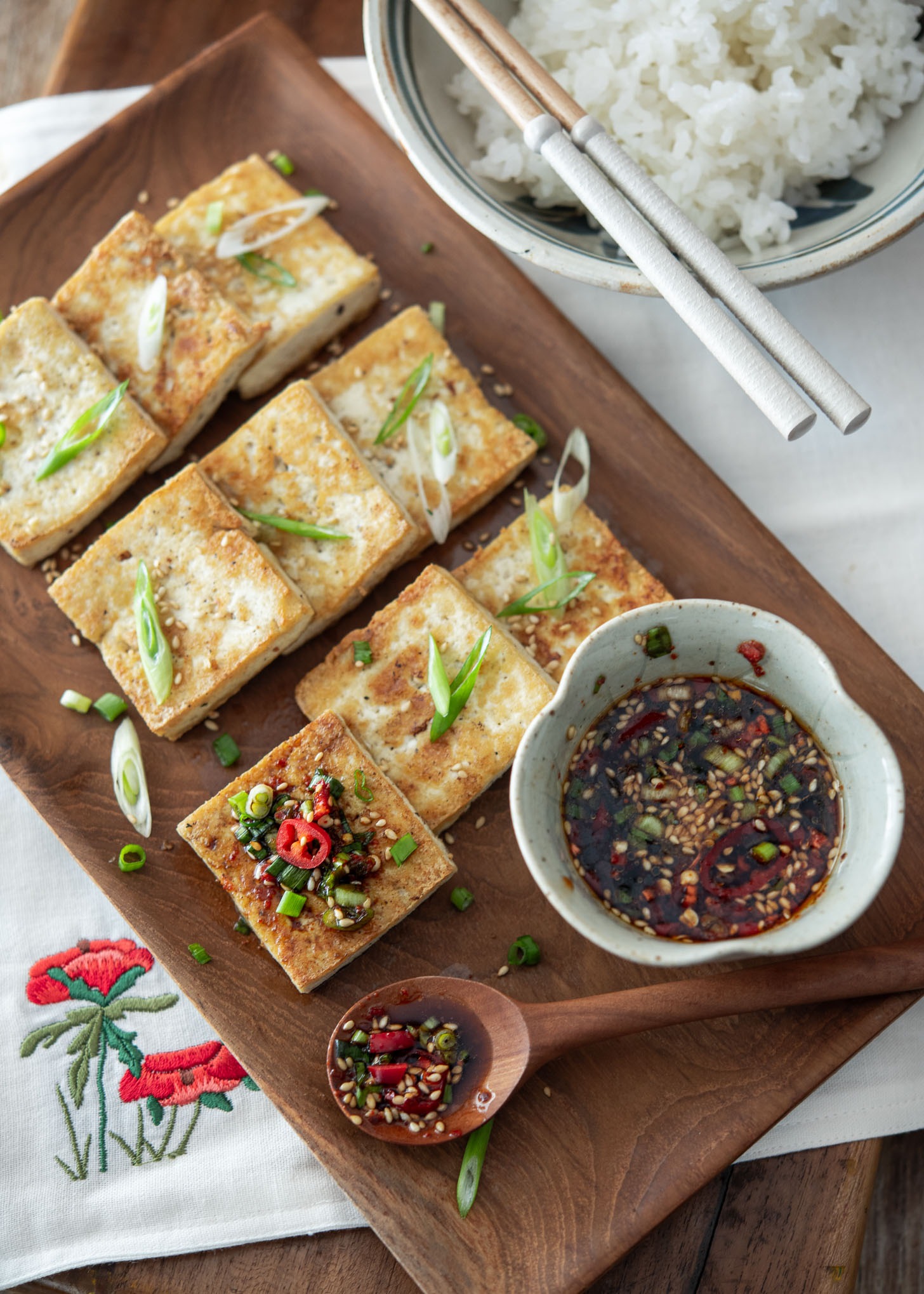Crispy pan-fried tofu slices topped with soy dipping sauce.
