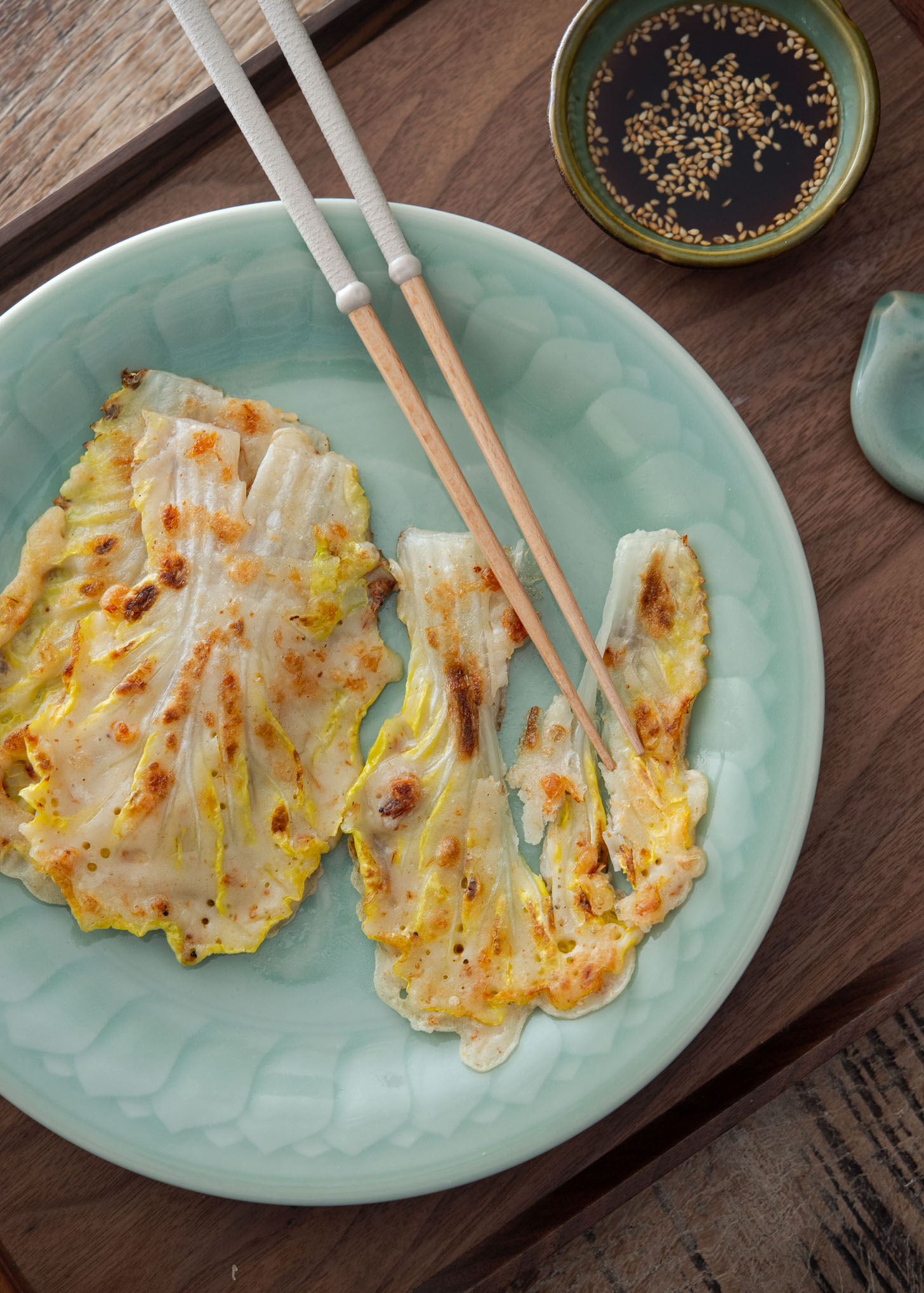 Korean cabbage pancake with chopsticks on a plate.