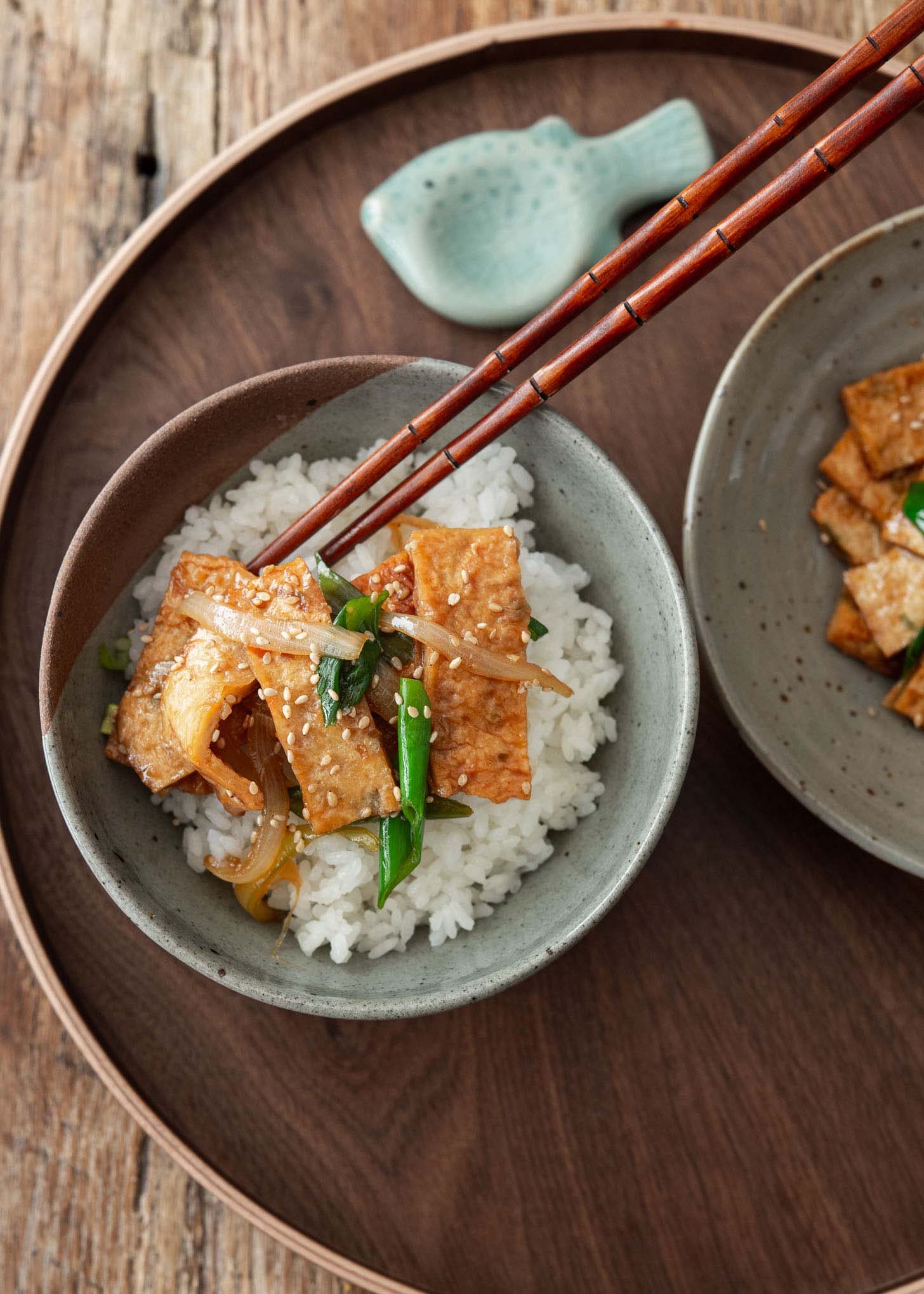 A bowl of rice topped with fish cake side dish.