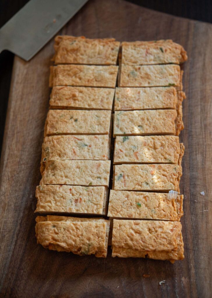 Fish cake sheets are sliced into bite size pieces.