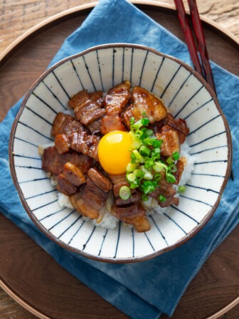 Butadon with pork belly and egg yolk in a serving bowl.