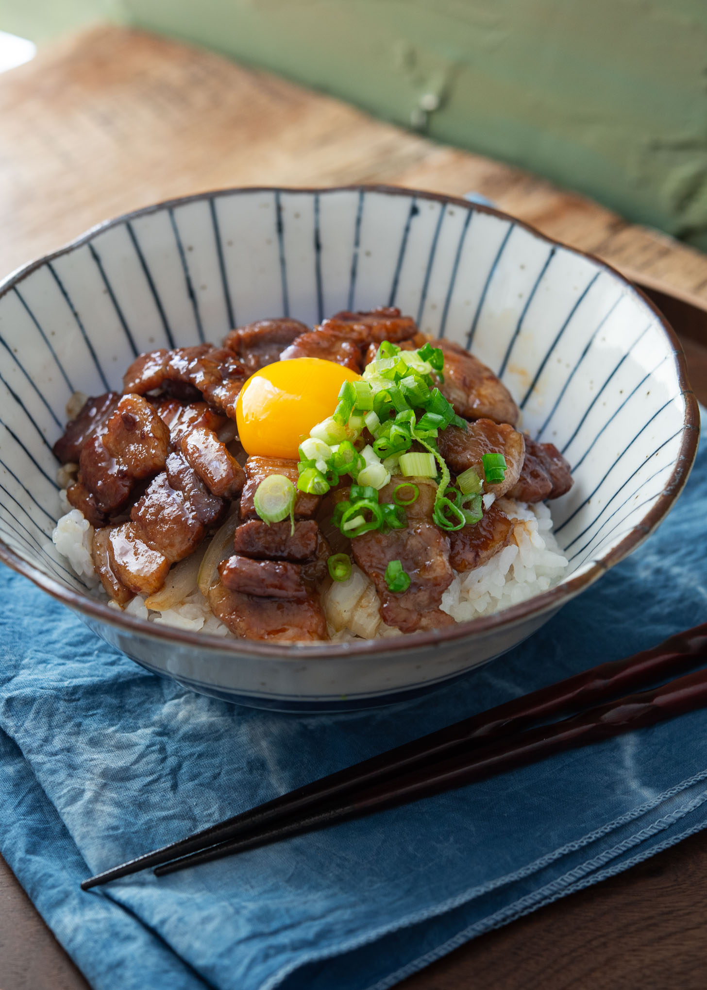 Japanese pork rice bowl garnished with egg yolk.