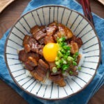Butadon with pork belly and egg yolk in a serving bowl.