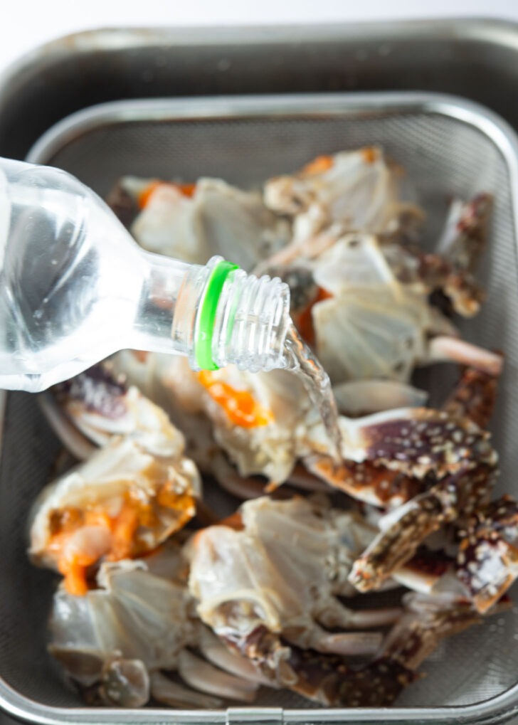 Pouring soju over cleaned crab.