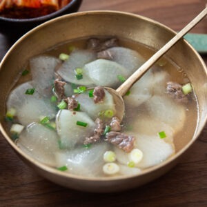 Beef radish soup in a bowl with a spoon.