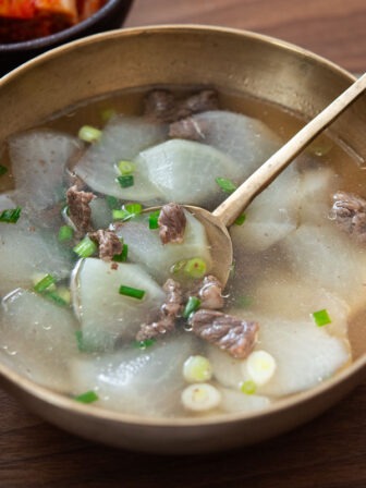 Beef radish soup in a bowl with a spoon.