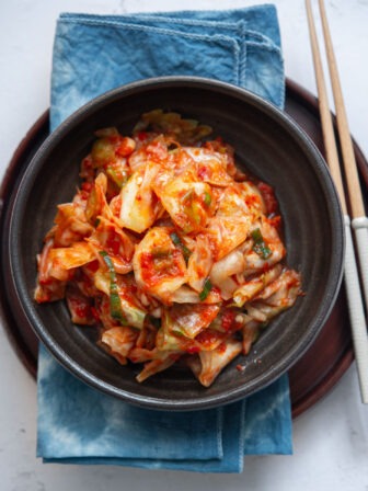 Green cabbage kimchi in a serving dish.