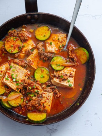 Beef and tofu stew with zucchini in a skillet.