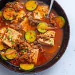 Beef and tofu stew with zucchini in a skillet.