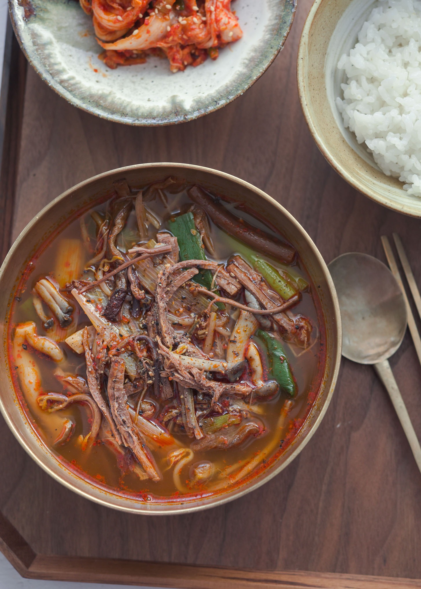 Yukgaejang in a bowl and served with rice and kimchi.