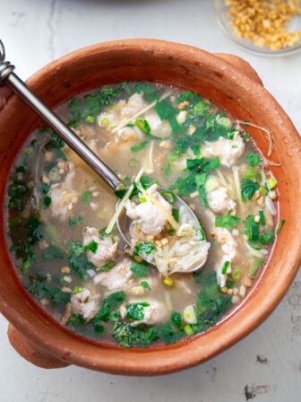 Thai chicken rice soup (Khao Tom Gai) in a bowl.