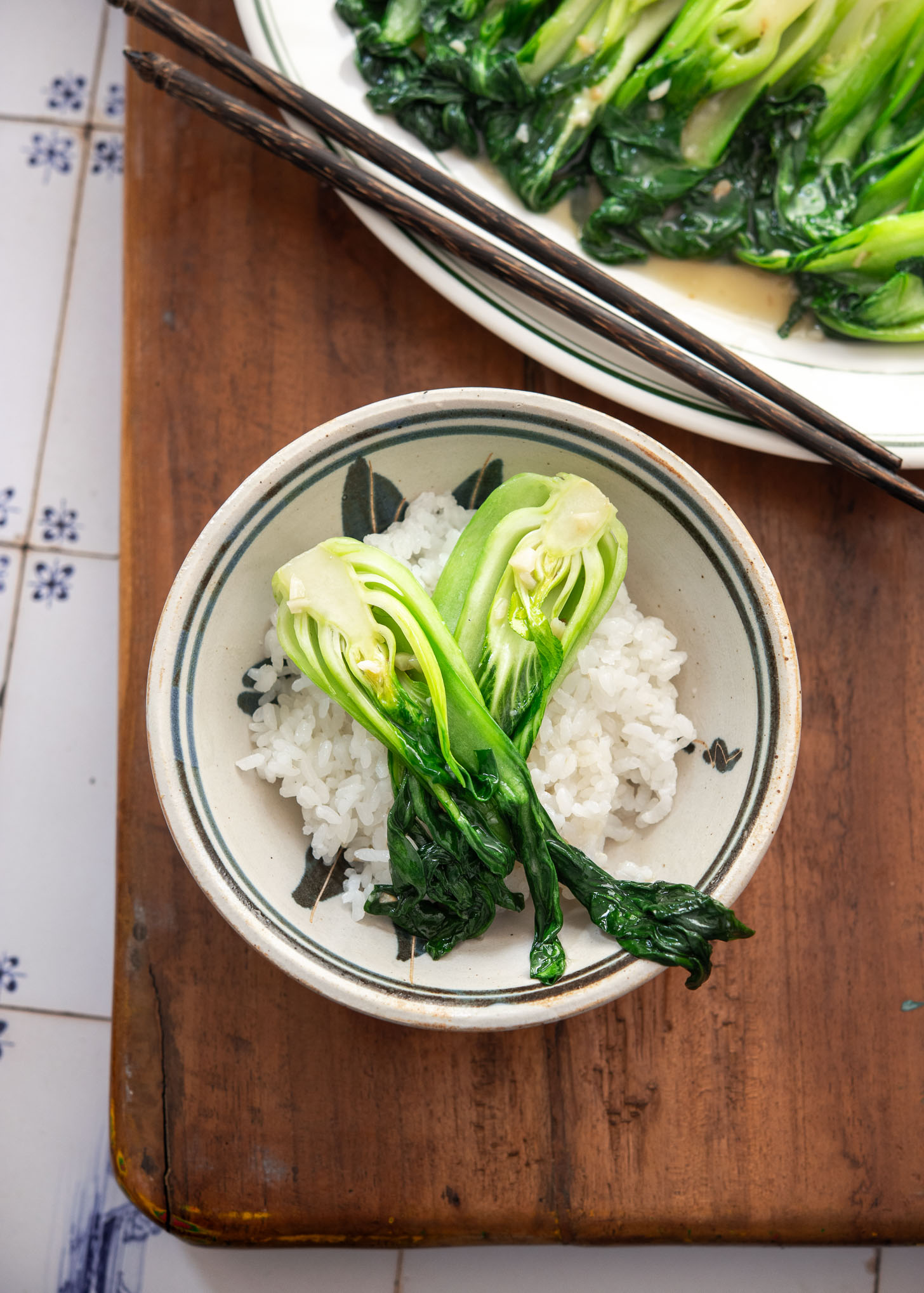 Bok choy stir-fry served over steamed white rice in a bowl.