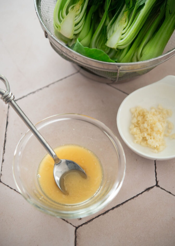 Stir-fry sauce for bok choy made with chicken bouillon, ginger, and cornstarch in a small bowl.