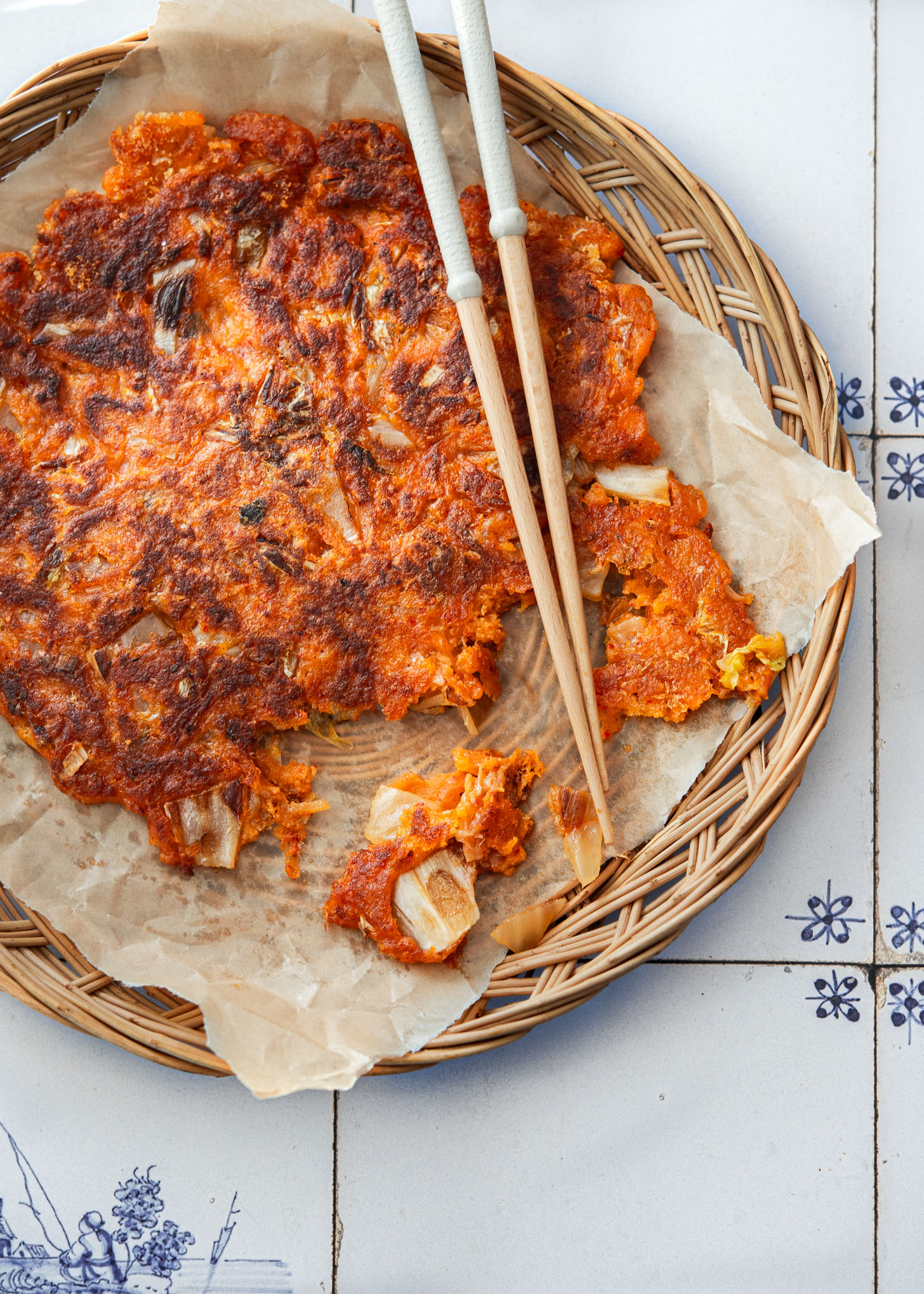 Crispy kimchi jeon (kimchi buchimgae) with chopsticks.